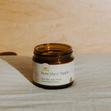 Jar of honeybee hippie sunscreen on a wooden surface