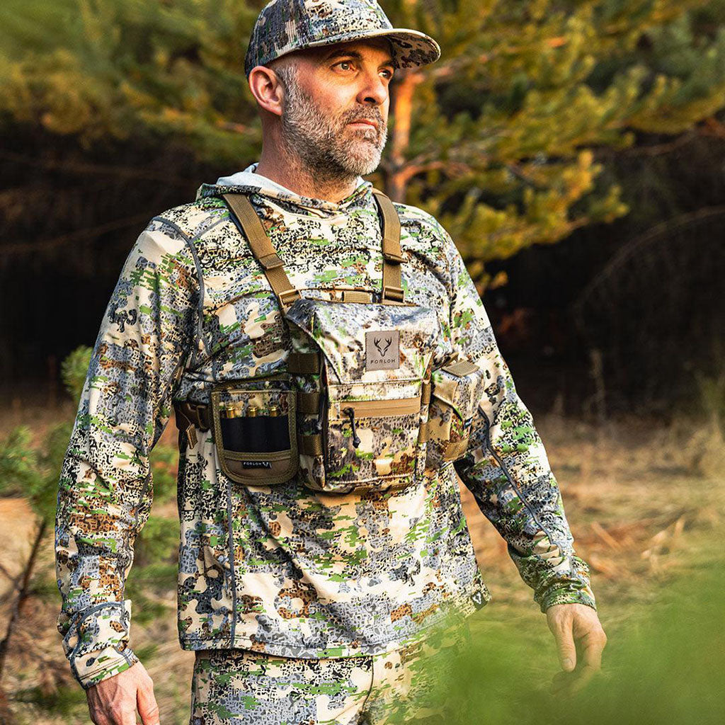 Man in Forloh full camouflage hunting outfit with tactical gear in a forest setting