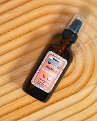 Showcase VanMan's Protection Oils, a natural oil blend in an amber bottle with a retro van label, placed on a textured wooden surface.
