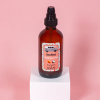 VanMan's Protection Oils bottle with coconut, almond, and olive blend sits on a white cube.
