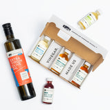 Collection of vinegar bottles with a box labeled 'American Vinegar Works' on a white background