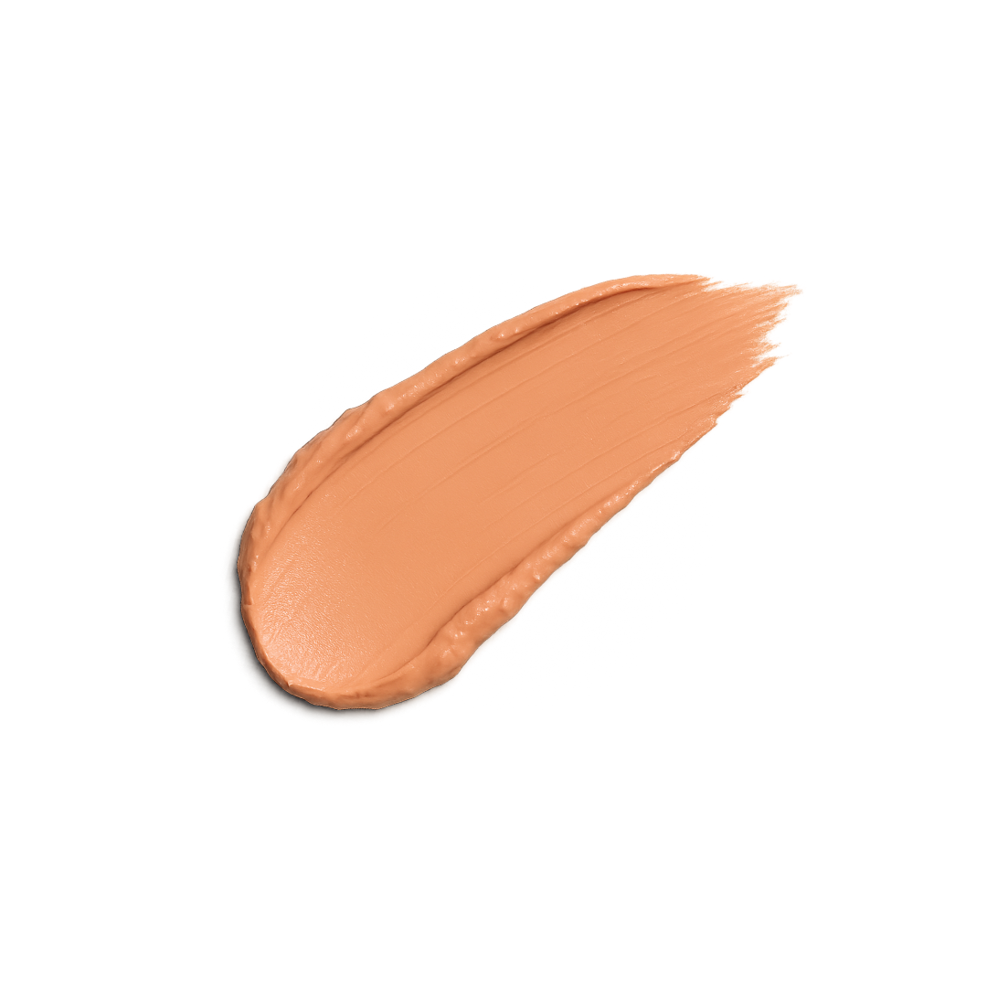Close-up shows a swatch of beige foundation makeup on a white background.
