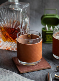 Glass with leather sleeve on a coaster 