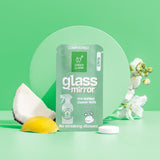 Green Llama showcases their compostable, citrus-scented glass and mirror cleaner refill alongside coconut, lemon, and white flowers.