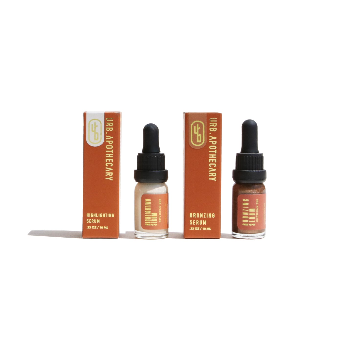 Urb Apothecary displays their highlighting and bronzing serum skincare products with boxes and dropper bottles.
