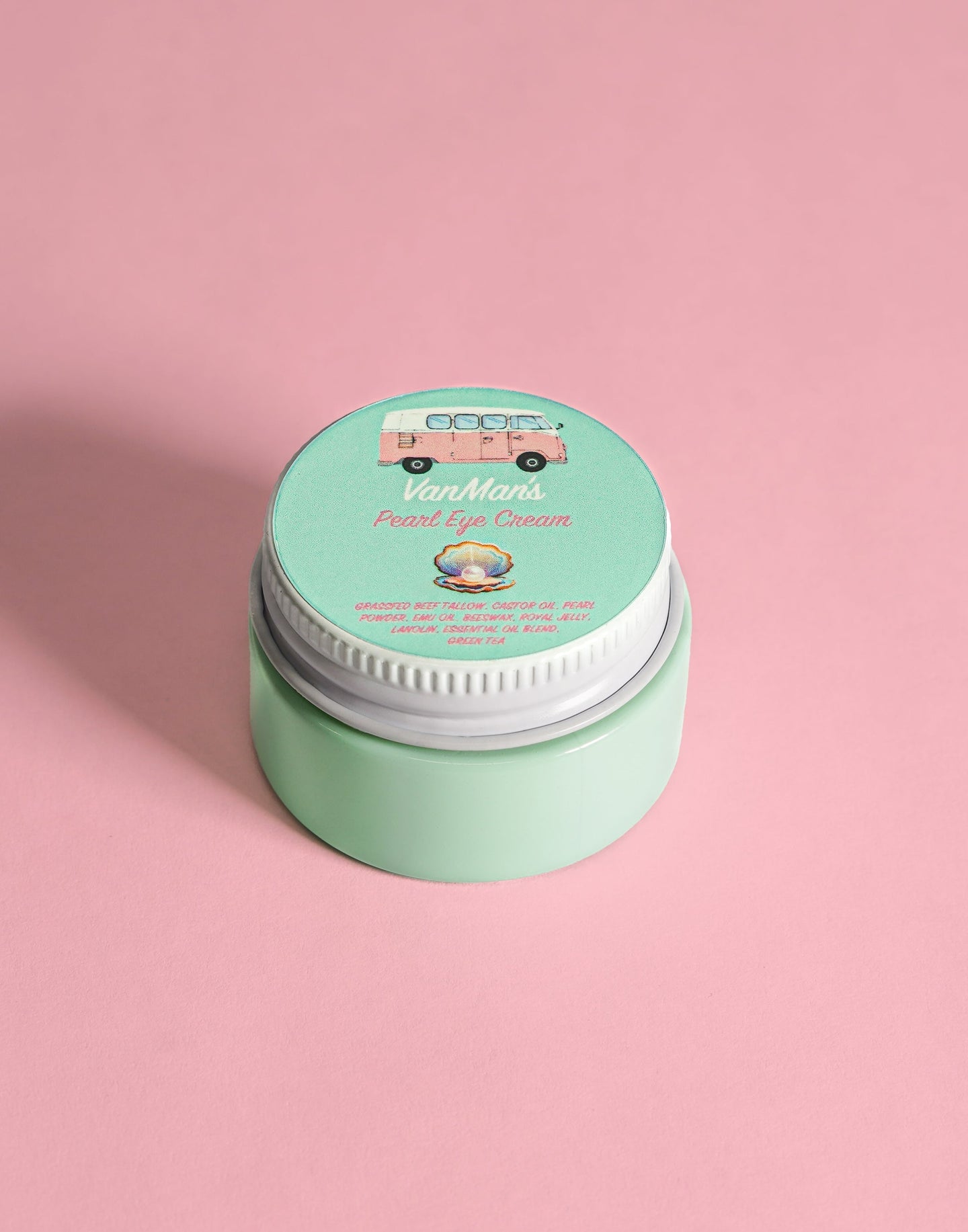 VanMan's Pearl Eye Cream, featuring natural ingredients and a vintage van illustration, sits prettily on a pink surface.
