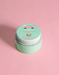 VanMan's Pearl Eye Cream, featuring natural ingredients and a vintage van illustration, sits prettily on a pink surface.
