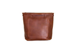 Displays a stylish, light brown leather bucket bag with detailed stitching and a soft, supple texture.
