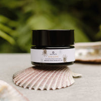 Cosmetic jar labeled 'Sun Love' on a shell with a natural background