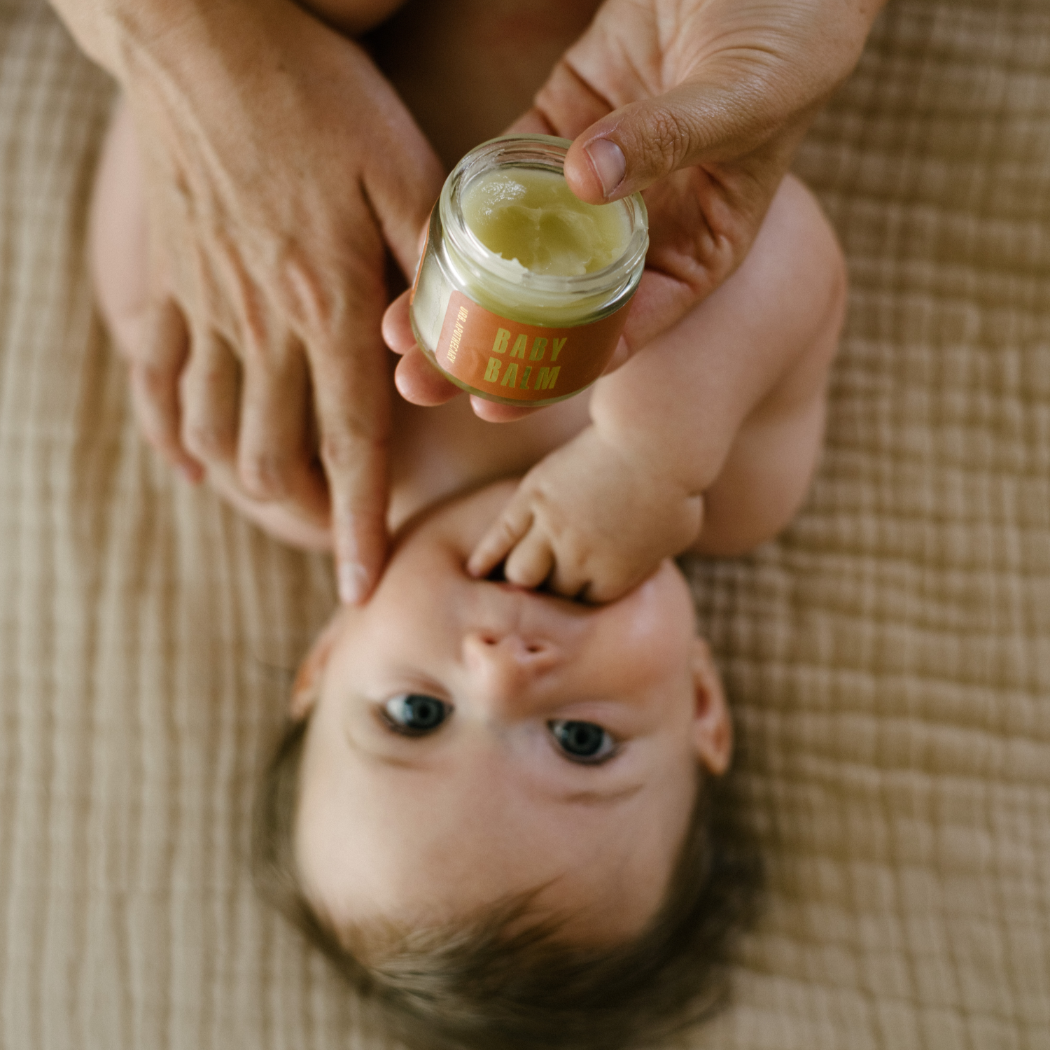 Mother applying baby balm to baby