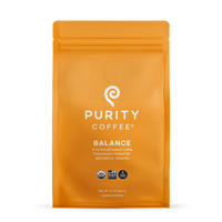 Showcases a sealed orange bag of Purity Coffee Balance, a consciously crafted, two-thirds decaffeinated, USDA-organic ground coffee for metabolic health.
