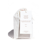 A muslin bag tied with a drawstring showcases a tag advertising Eucalyptus, Rosehip, Cactus Milk, and Lavender bath soaks for a luxurious, relaxing bath experience.

