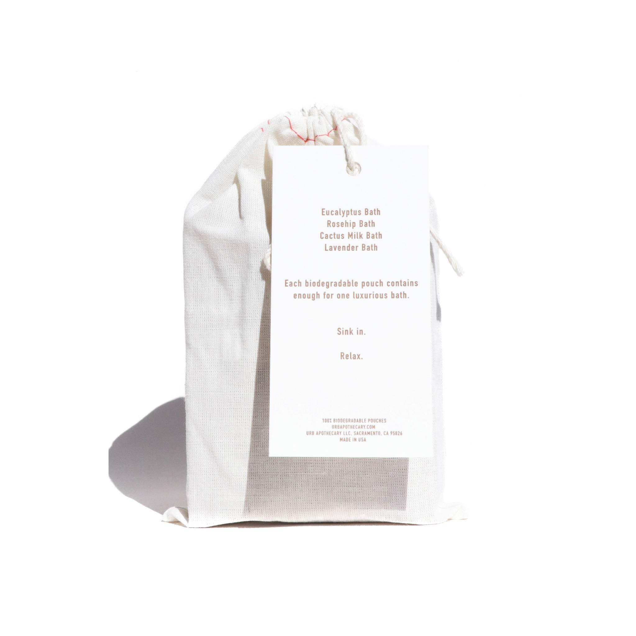 A muslin bag tied with a drawstring showcases a tag advertising Eucalyptus, Rosehip, Cactus Milk, and Lavender bath soaks for a luxurious, relaxing bath experience.
