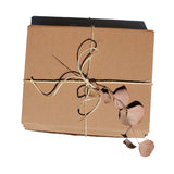 A brown cardboard gift box receives a rustic touch with twine and dried eucalyptus leaves.
