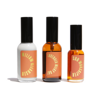Three glass bottles of Urb Apothecary skincare products, including Willow Glow Cleanser, Lavender Milky Oat, and Sun Worshiper, stand on a white background.

