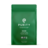 Purity Coffee sells "Ease," a dark roast ground coffee designed to support digestive health, packaged in a green bag with USDA Organic and Bird Friendly certifications.
