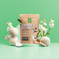 Green Llama's eco-friendly laundry powder presents a stylish clean with wool dryer balls, fresh flowers, and a wooden scoop.
