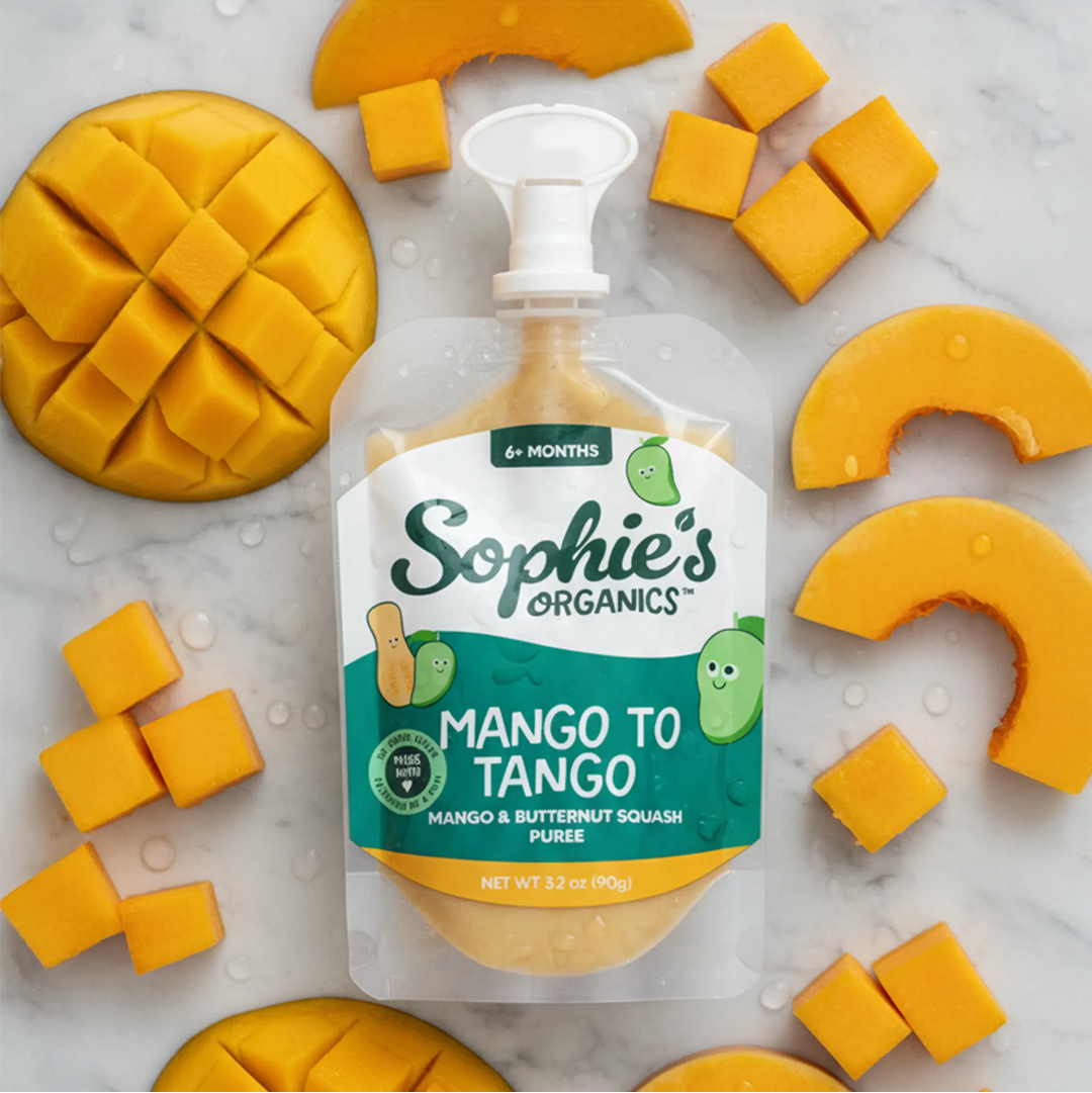 Sophie's Organics mango and butternut squash puree packaging surrounded by mango pieces on a marble surface.