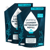 Two dark blue Puracy laundry detergent refill pouches promise 192 loads and a fresh linen scent.
