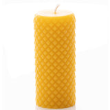 A natural beeswax candle displays its unique honeycomb texture.
