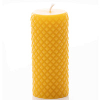 A natural beeswax candle displays its unique honeycomb texture.
