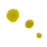 Three drops of golden yellow beauty oil shimmer on a white background.
