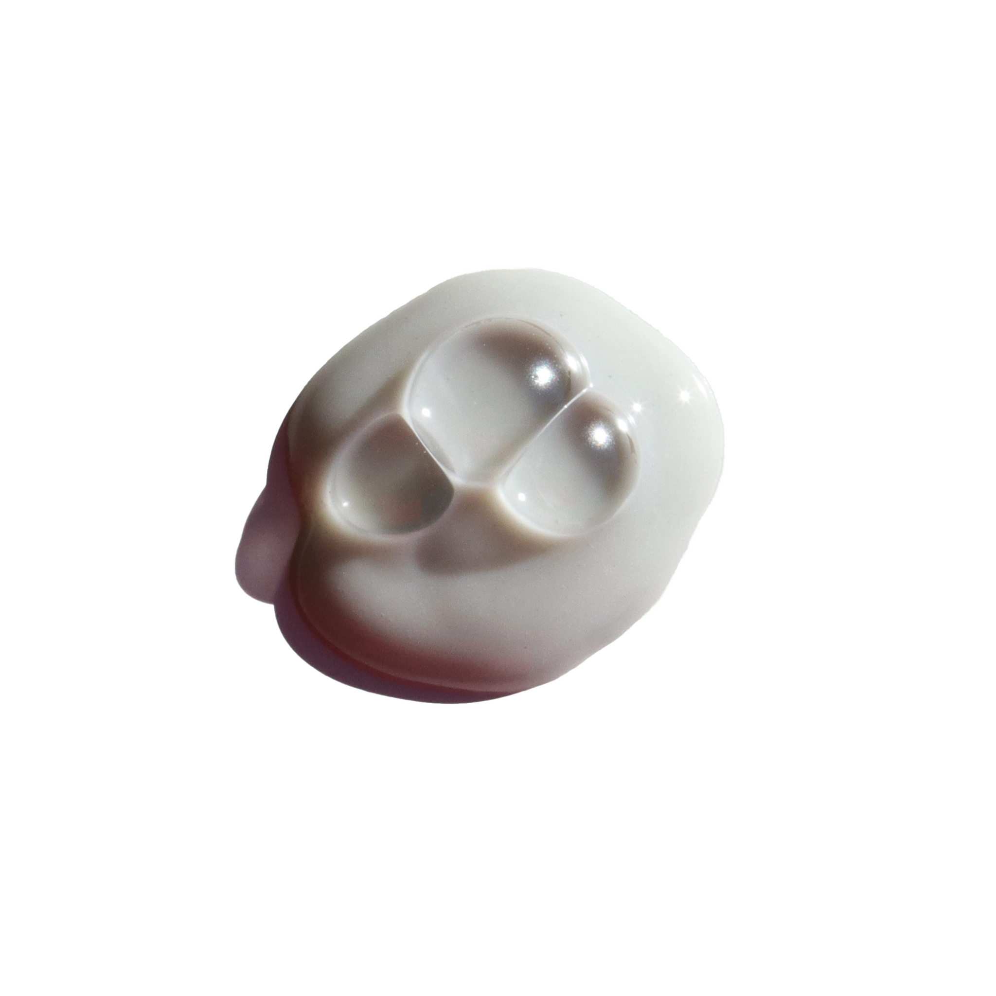 Close-up shows a dollop of white beauty cream containing three clear gel capsules.
