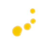 Golden beauty oil droplets gleam against a clean white background.
