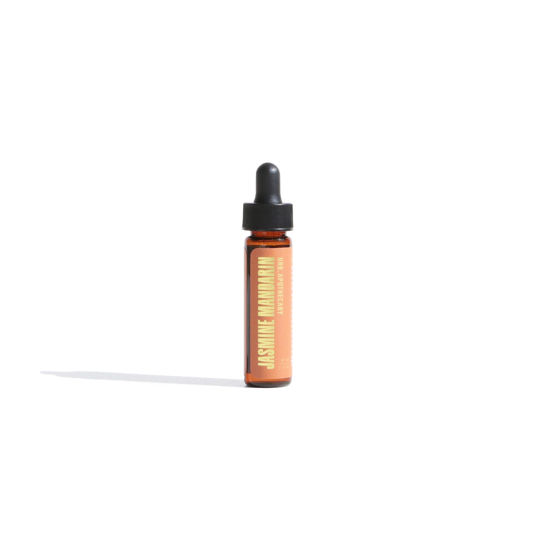 Jasmine Mandarin aromatherapy oil in a small bottle with a dropper cap sits on a white surface.
