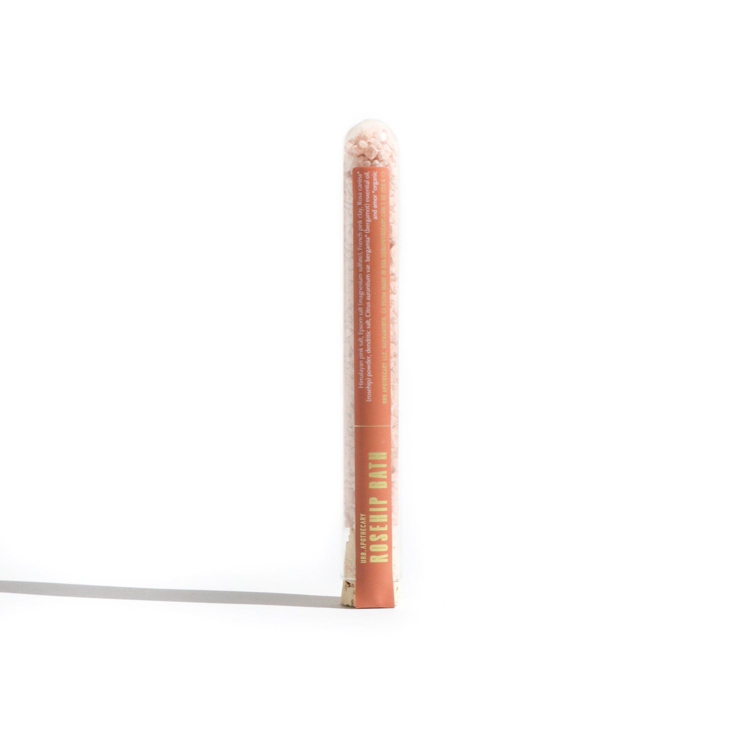 Showcase Urb. Apothecary Rosehip Bath salts in a clear tube, highlighting its blend of Himalayan pink salt and essential oils.
